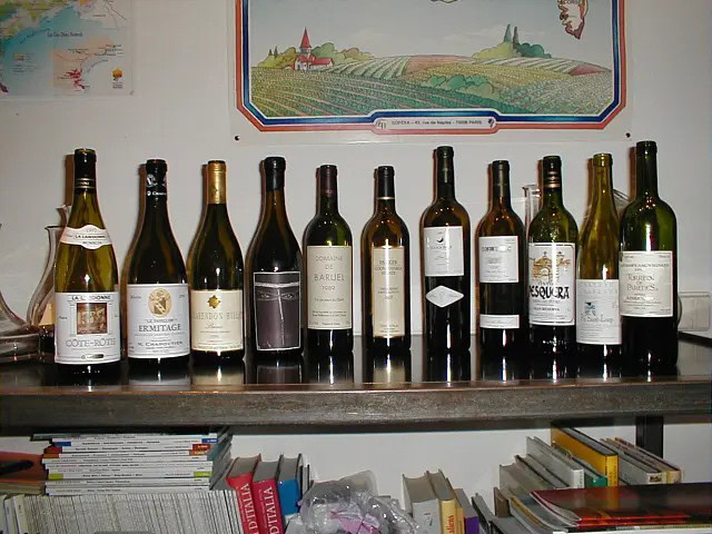 Regal mit Weinflaschen vor Kartenbild.